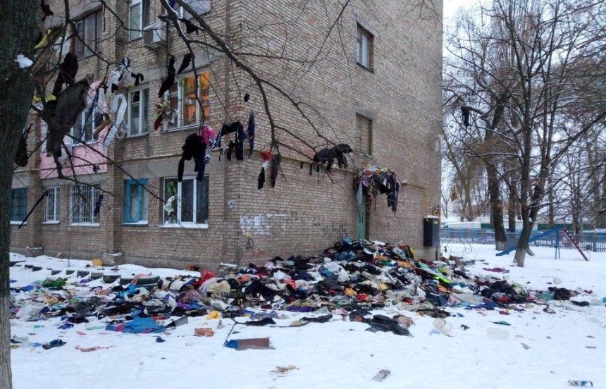 Вещи на ветер: на Борщаговке двор закидали одеждой (фото)