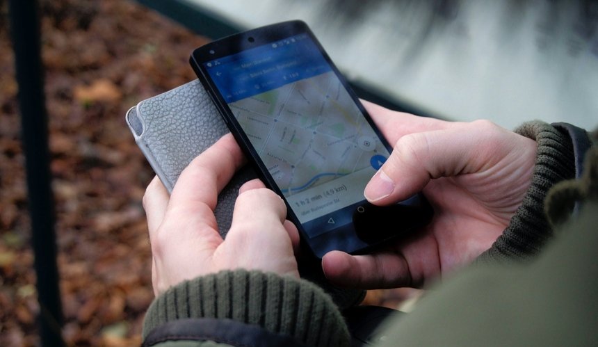 Людина тримає смартфон із відкритим додатком Google Maps