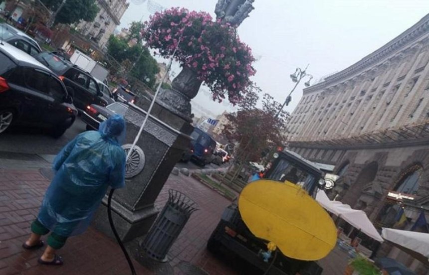 Идеальная погода: столичные коммунальщики поливают клумбы под дождем (фото)