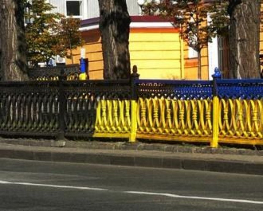 Киевлянин перекрасил сине-желтый забор снова в черный