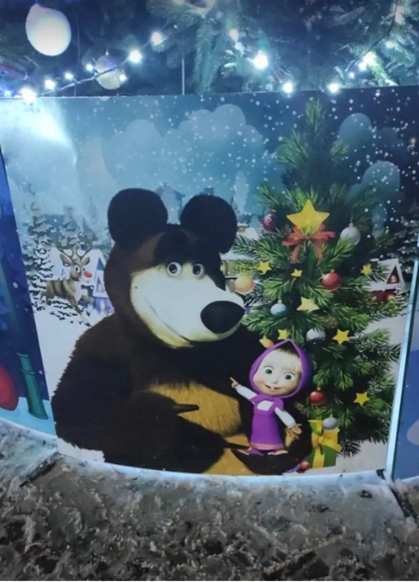 У селі Коцюбинське під Києвом встановили ялинку, огорожа якої задекорована світлинами з мультфільму "Маша та ведмідь" та фото Діда Мороза й Снігурки в кокошнику