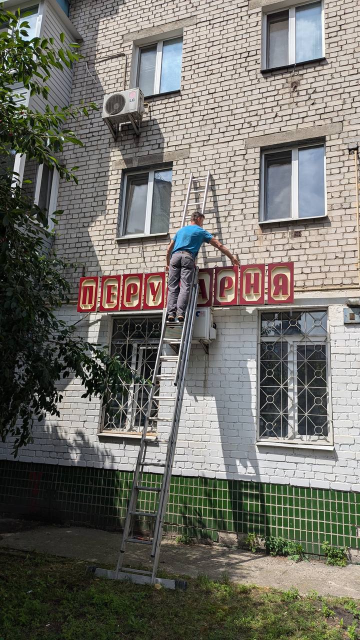 Відреставровану вивіску “Перукарня” повернули на історичне місце на Подолі в Києві: як вона виглядає